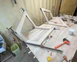 Creating the legs of the Ambry Silver Maple Conference Table. Two wood legs are combined at an angle.